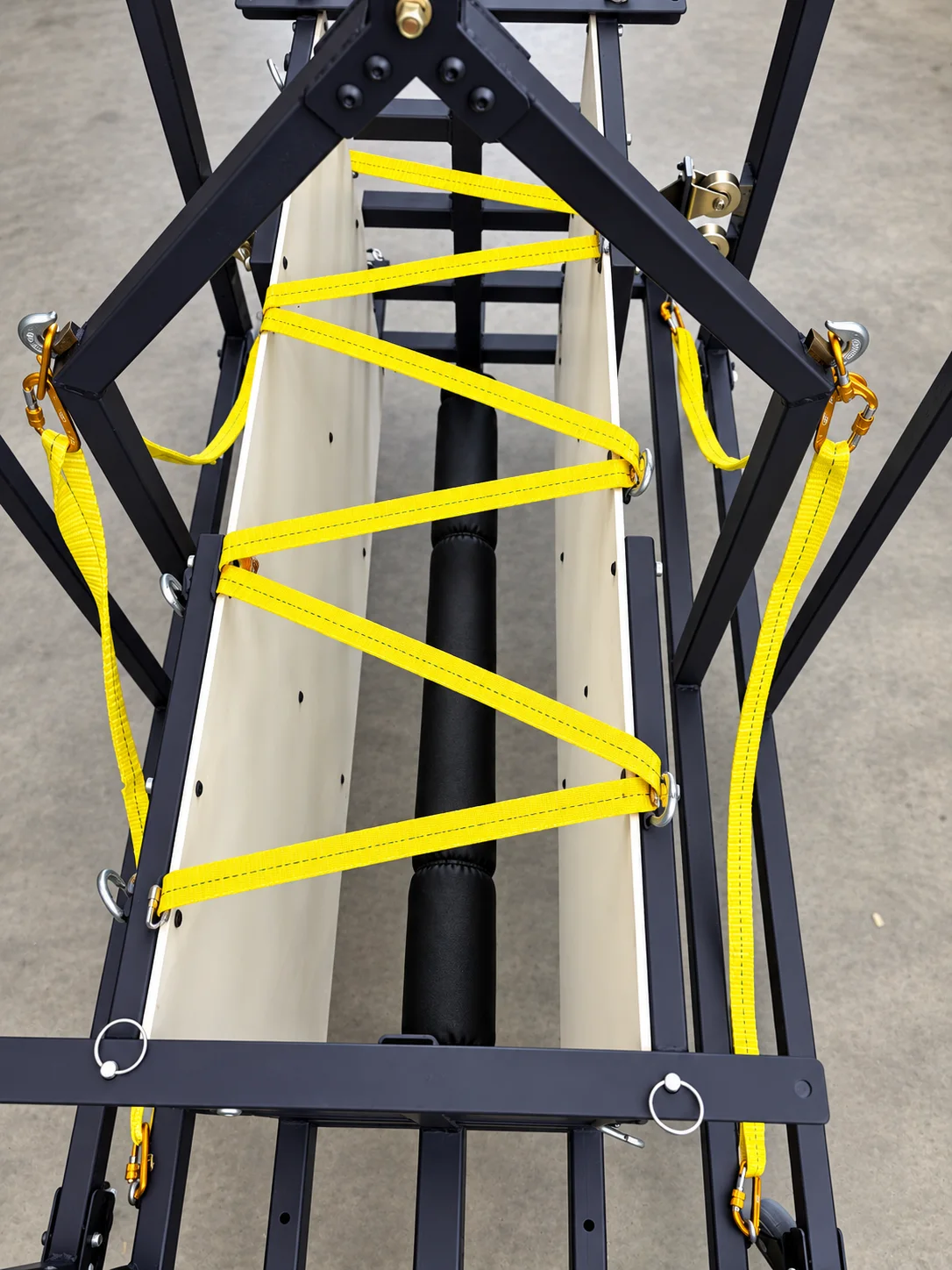 Top-down view of the chute with yellow webbing laced back and forth across the padded central bar.